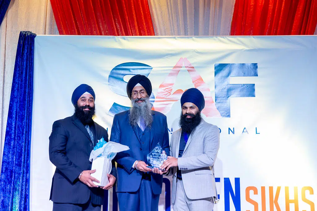 Dr Suneet Singh Tulli handed over an appreciation award by Manveer and Shamandeep Singh of SAF International.
