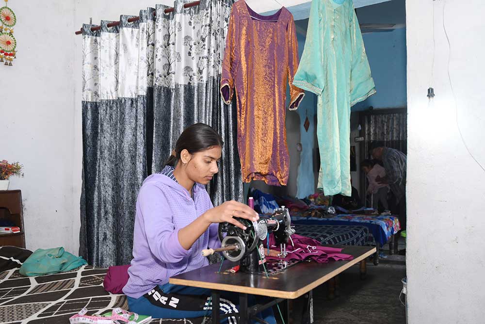 Mehreen at home – stitching clothes.