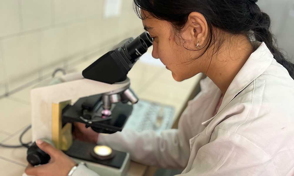 Sponsored student Mehakpreet in her lab coat after completing medical studies
